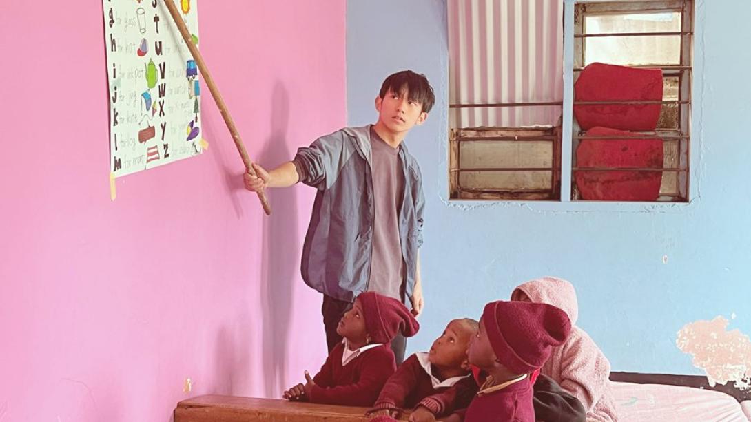 タンザニアの学校で子供たちに英語のアルファベットを教える日本人高校生ボランティア